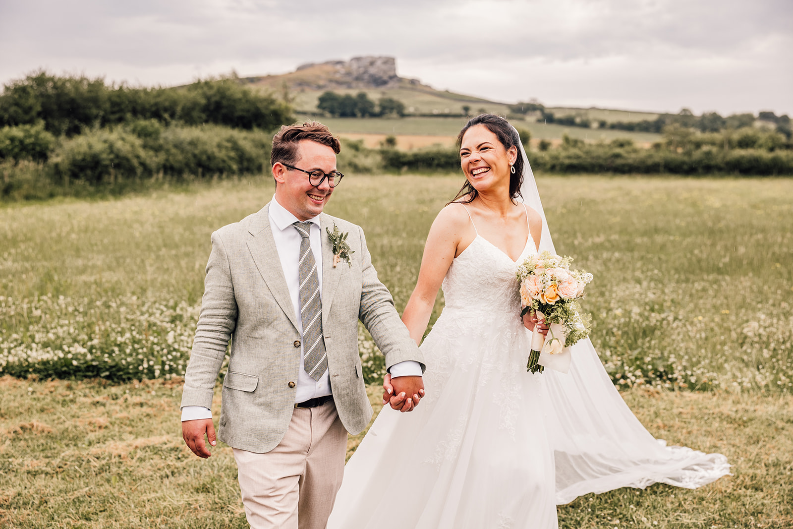 bride and groom stroll through outdoor venue with yorkshire backdrop