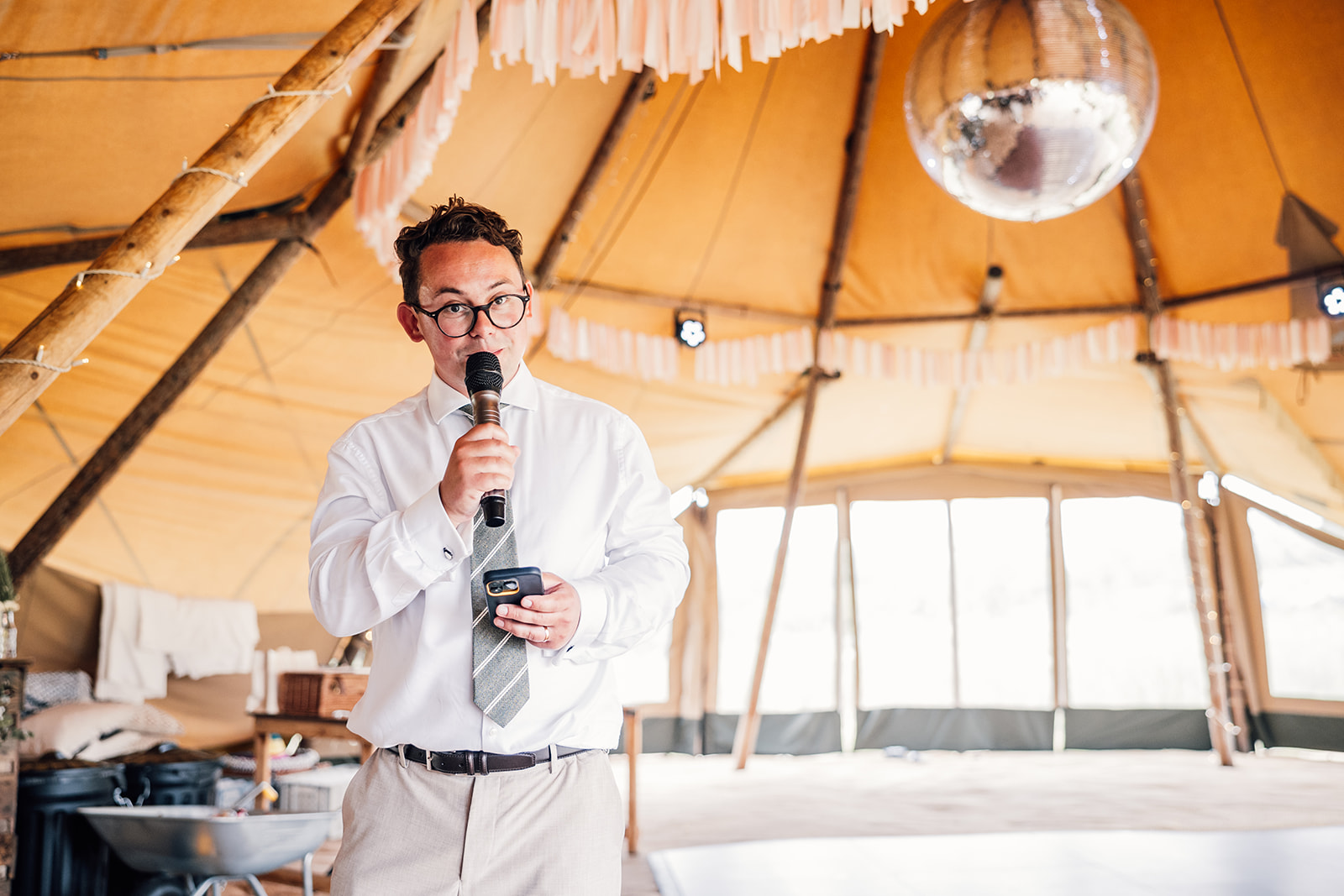 giant mirror ball in tipi as groom delivers his wedding speech